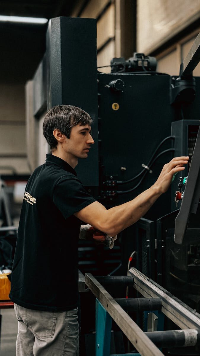 Photo by Bulat843 🌙 A focused worker operating heavy machinery in an industrial setting.