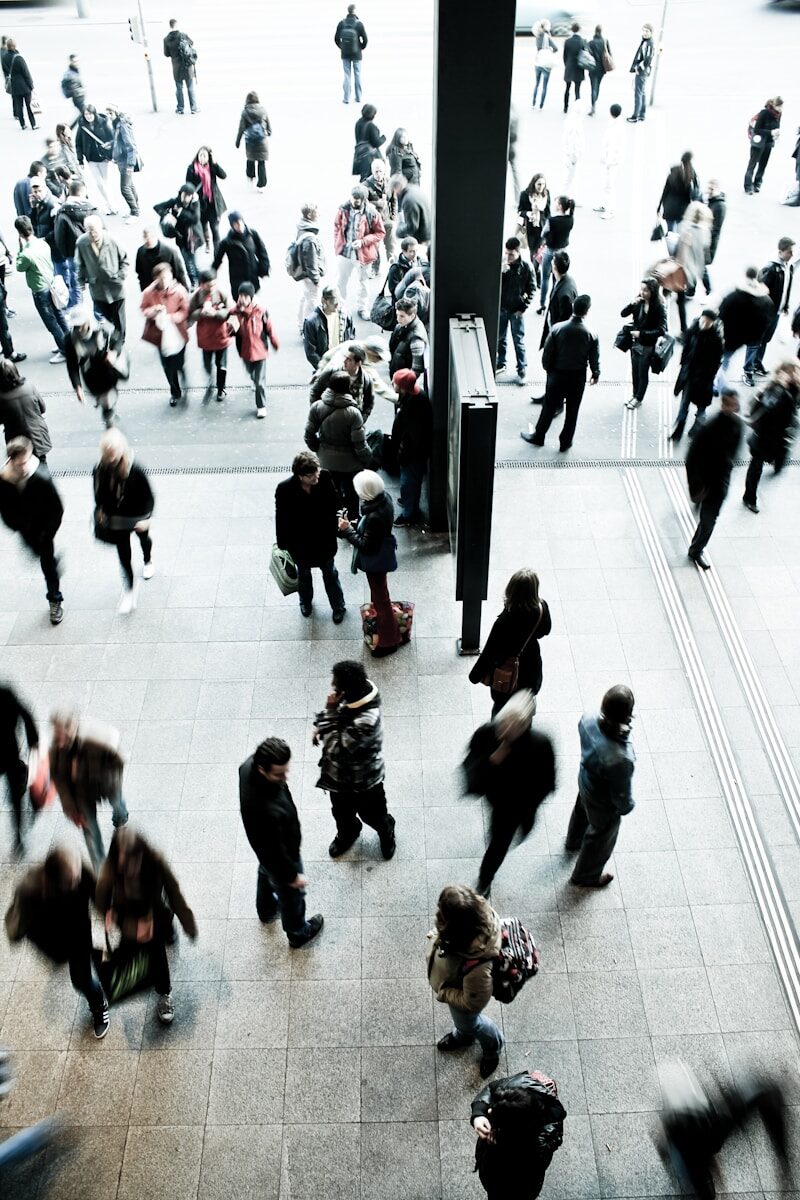 Photo by Timon Studler people walking on gray concrete floor