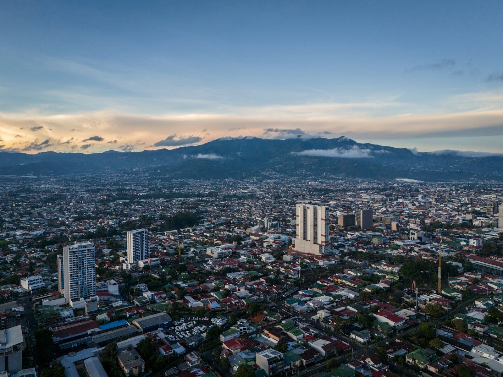 Photo by César Badilla Miranda an aerial view of a city with mountains in the background