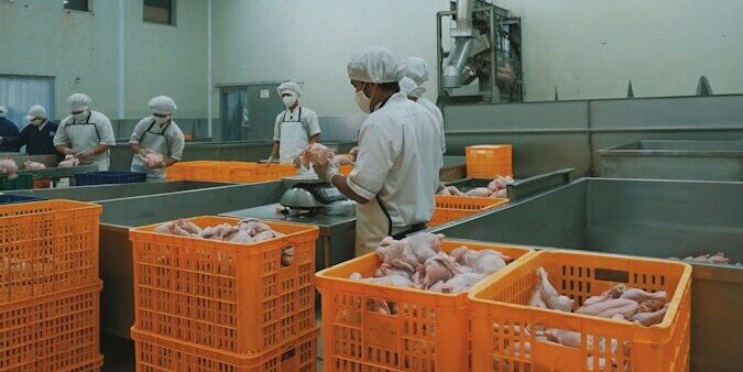 man in white dress shirt standing near orange plastic crate
