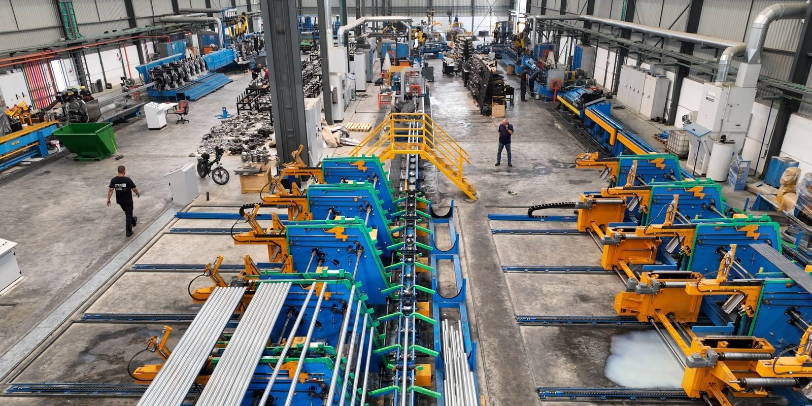 Aerial view of a large manufacturing plant interior with machinery and workers.