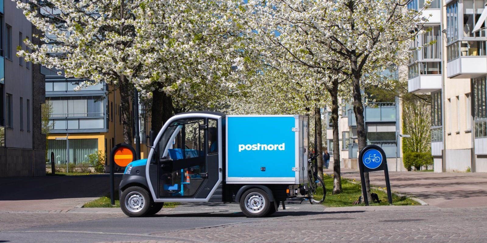 Electric delivery vehicle parked on a scenic street in Jönköping, Sweden during spring.