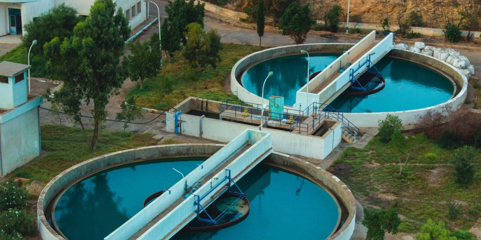 Drone shot of an advanced water purification plant surrounded by trees.