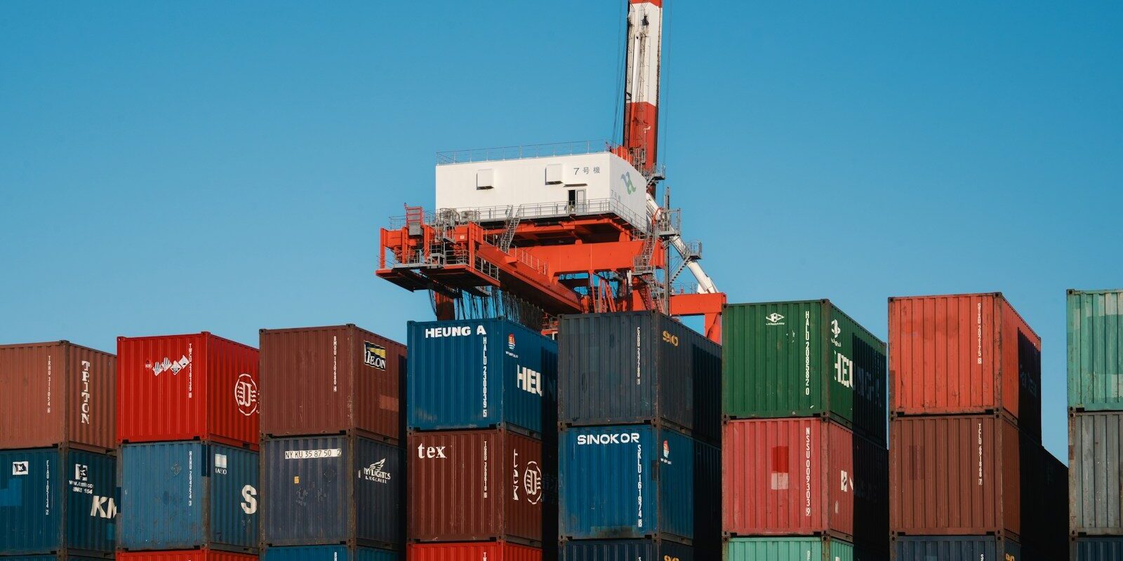 a crane is on top of a large stack of containers
