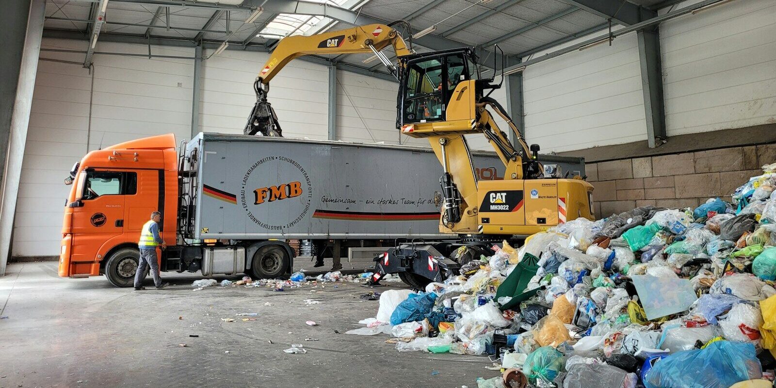 a large truck with a load of trash in a warehouse