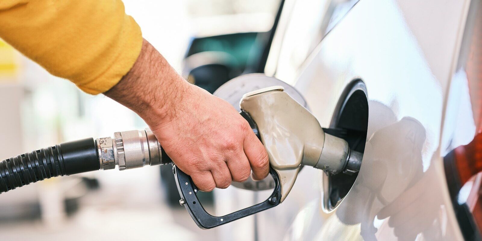 Photo by engin akyurt a man pumping gas into his car at a gas station