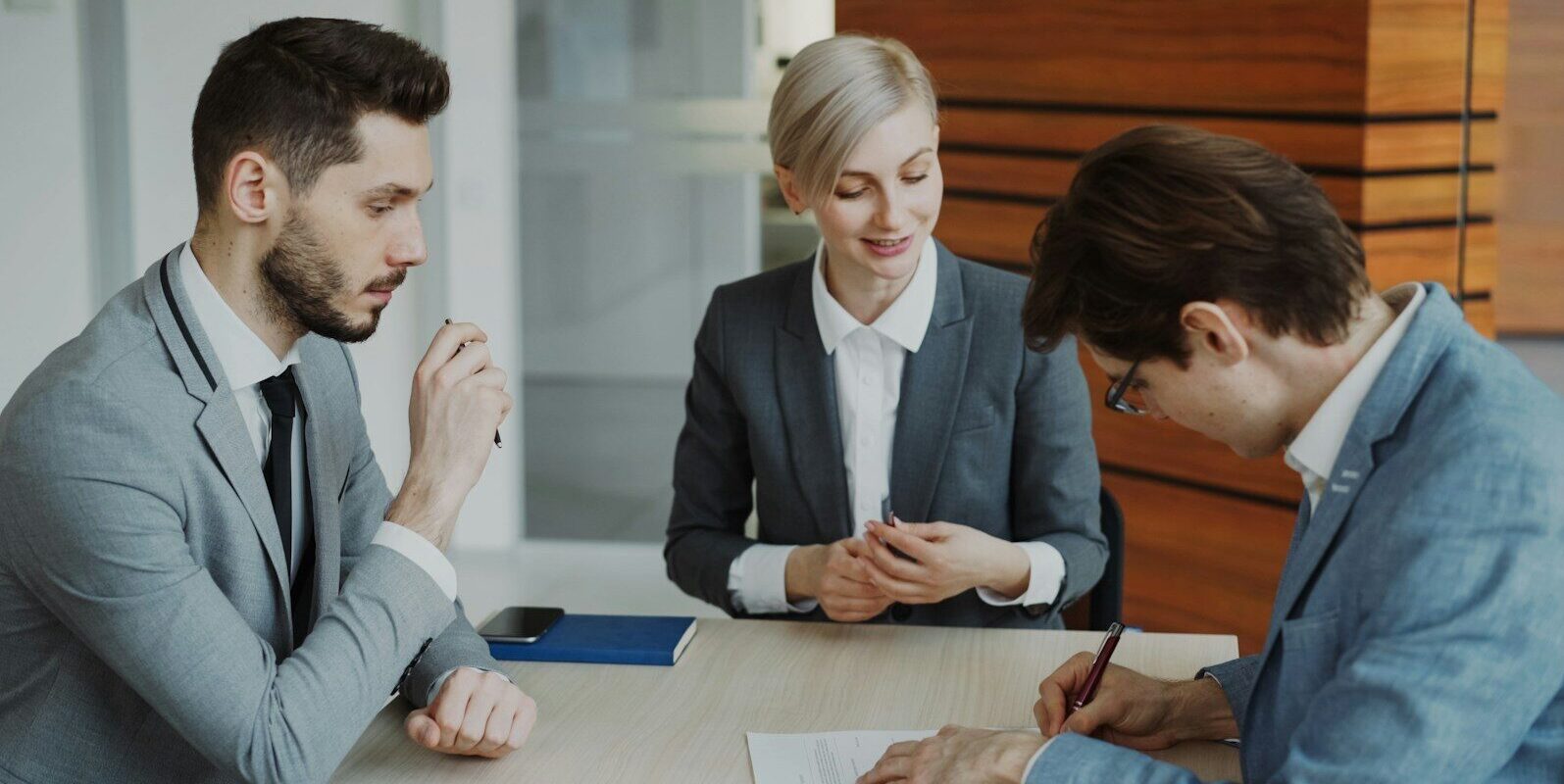 Business people signing a contract at a table