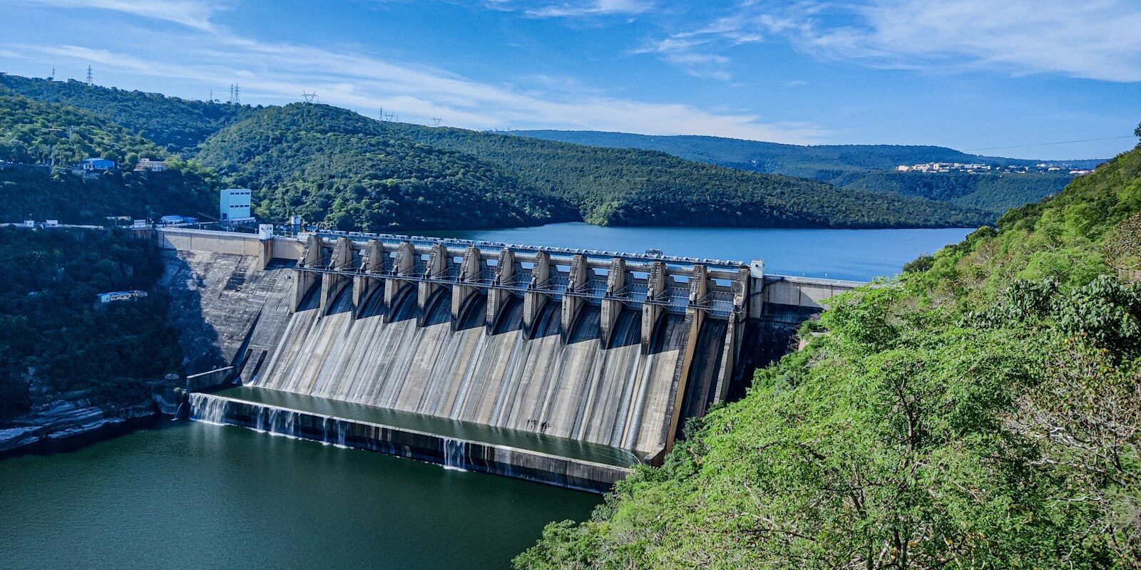 gray concrete dam under blue sky during daytime