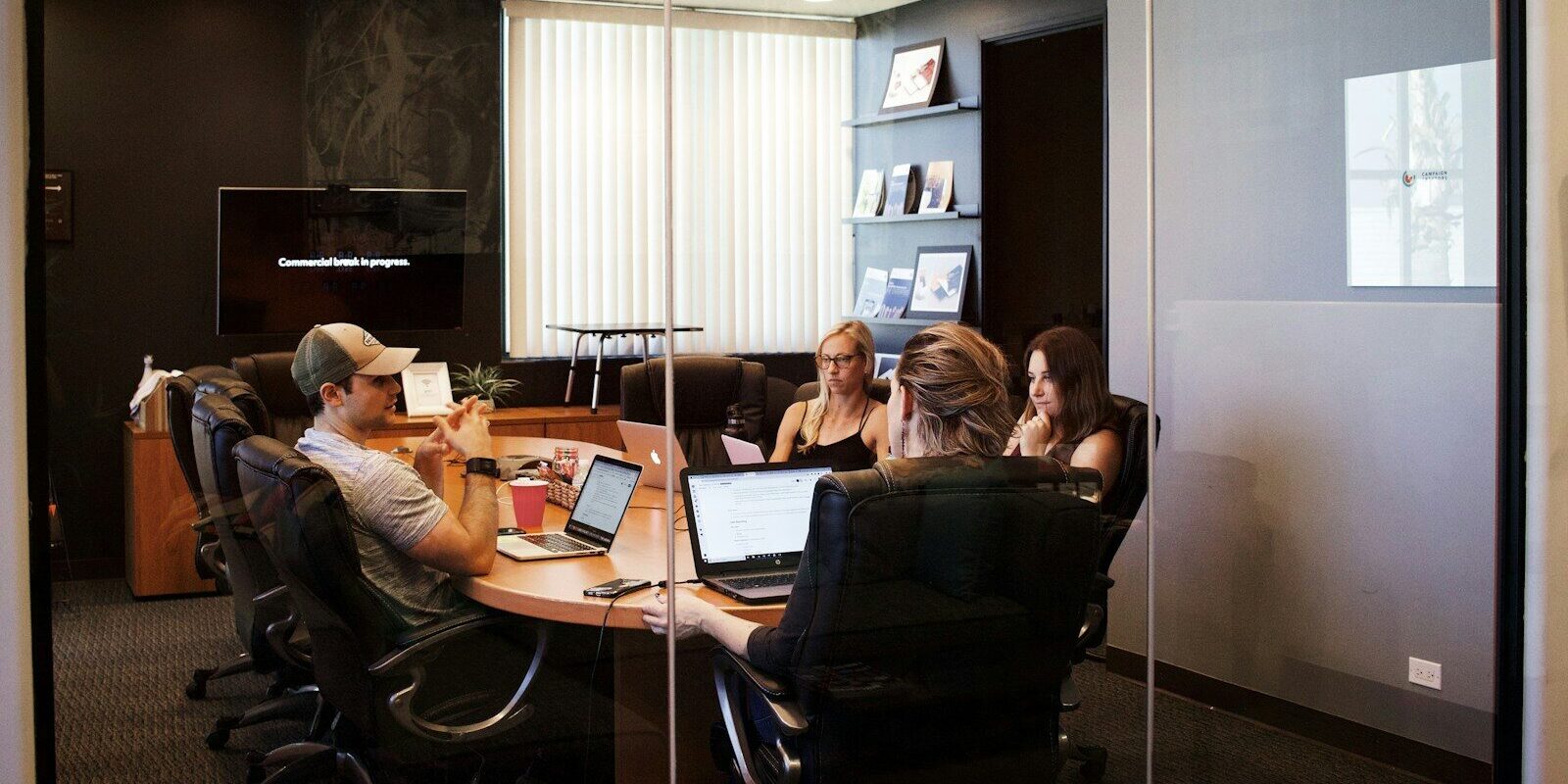 people sitting near table with laptop computer
