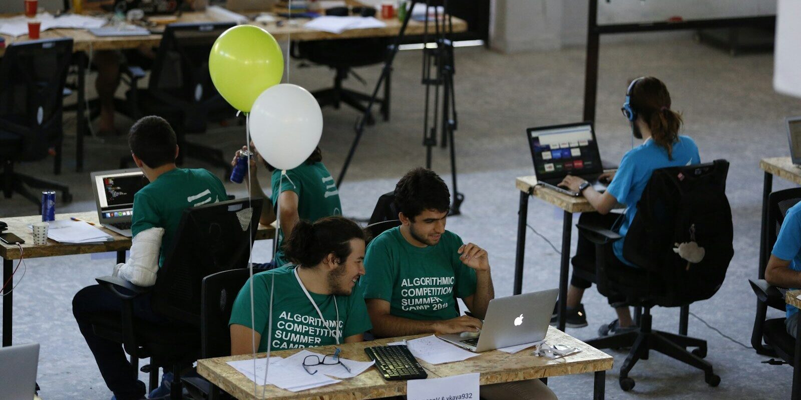 Photo by algoleague a group of people sitting at desks working on laptops